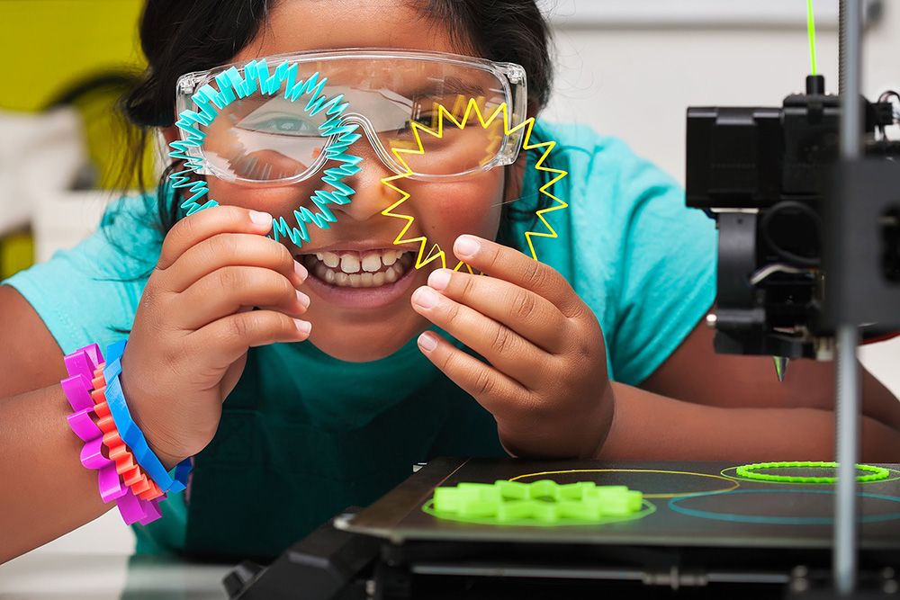 Happy kid holding up 3d printed designs